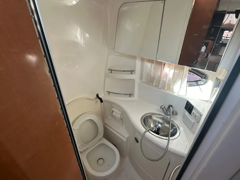Slide: The Image of 2007 Chaparral 310 Signature boat bathroom with toilet, sink, and mirror. - 29