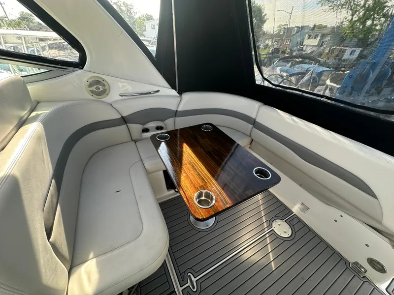 Slide: The Image of 2007 Chaparral 310 Signature boat interior with cushioned seating and wooden table. - 6