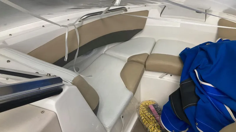 Slide: The Image of 2005 Larson 208LXi boat interior with beige seating and blue cover. - 12