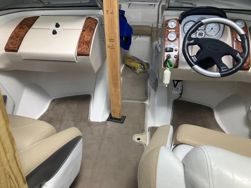 Slide: The Image of Interior of a 2005 Larson 208LXi boat with beige seating and wood accents. - 14