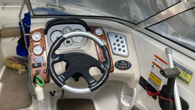 Slide: The Image of 2005 Larson 208LXi boat dashboard with steering wheel and control panel. - 3