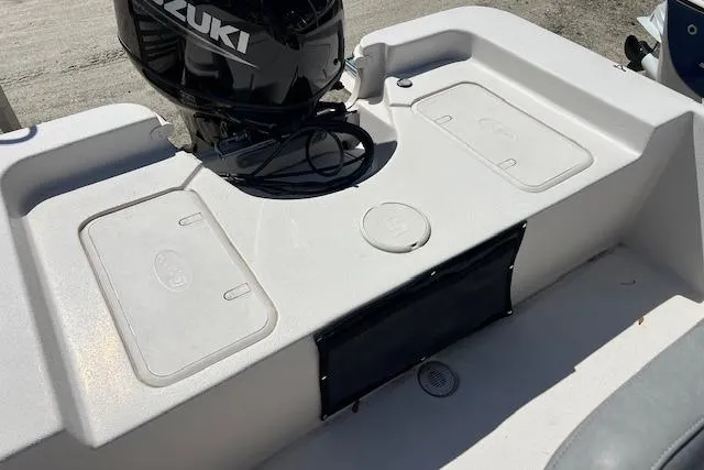 Slide: The Image of 2024 Carolina Skiff EV198 Sea Skiff with Suzuki outboard motor, featuring storage compartments. - 4