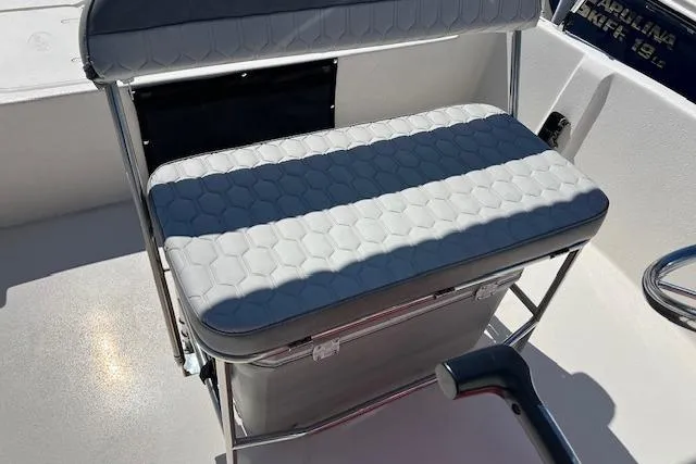 Slide: The Image of 2024 Carolina Skiff EV198 Sea Skiff boat seat with textured cushion and storage. - 5