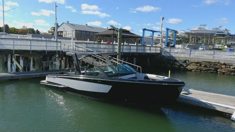 Slide: The Image of 2020 Aviara AV32 I/O boat docked at a marina under a clear blue sky. - 1