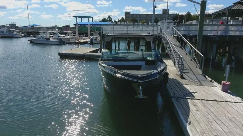 Slide: The Image of 2020 Aviara AV32 I/O boat docked at a marina under a sunny sky. - 29