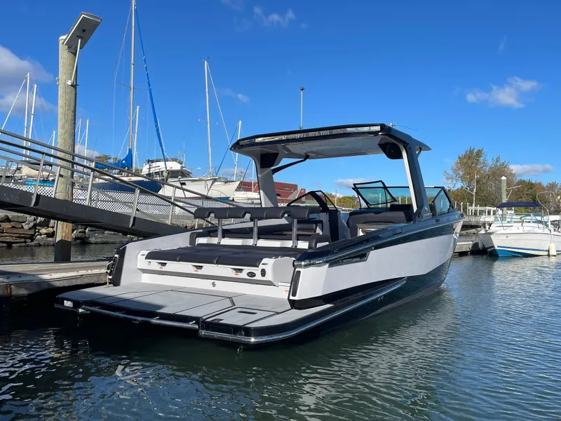 Slide: The Image of 2020 Aviara AV32 I/O boat docked in a marina under a clear blue sky. - 3