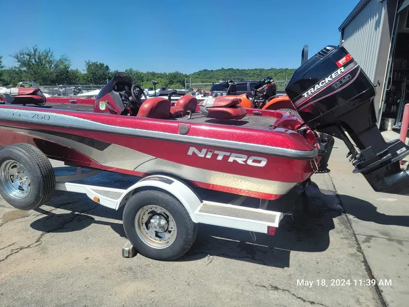Slide: The Image of 2004 Nitro NX 750 SC red fishing boat on trailer with Tracker motor. - 0