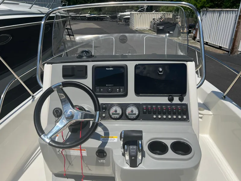 Slide: The Image of 2015 Boston Whaler 210 Dauntless boat console with steering wheel and navigation controls. - 3