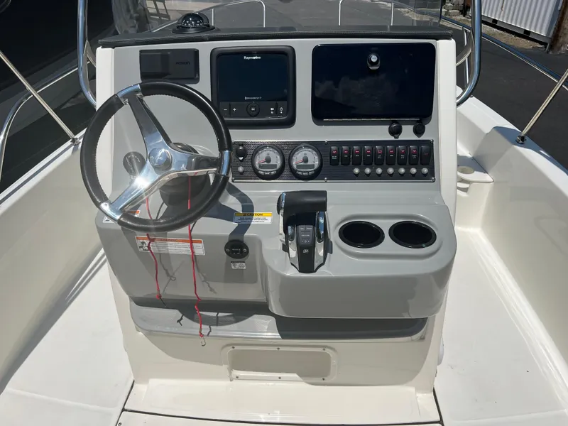 Slide: The Image of 2015 Boston Whaler 210 Dauntless boat console with steering wheel and navigation controls. - 4