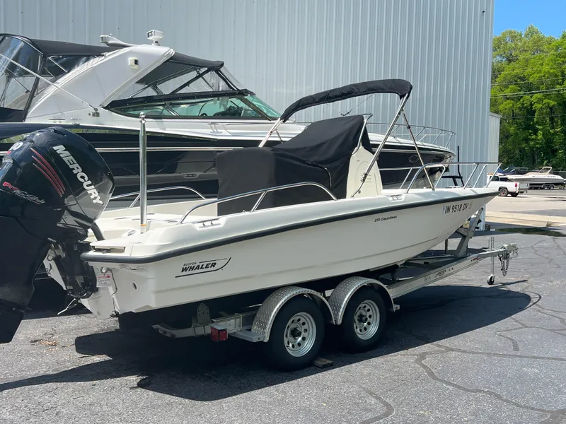 Slide: The Image of 2015 Boston Whaler 210 Dauntless boat on a trailer with a Mercury outboard motor. - 7