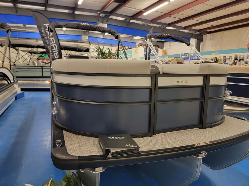 Slide: The Image of 2024 Harris Cruiser 230 pontoon boat on display in a showroom. - 1