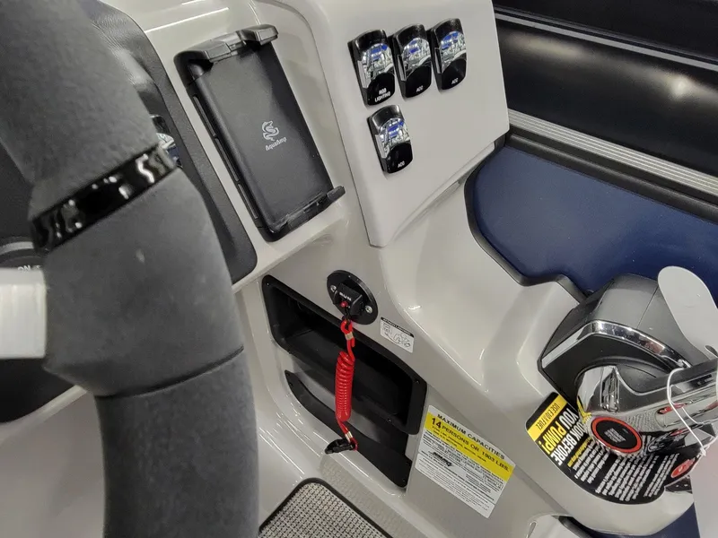 Slide: The Image of 2024 Harris Cruiser 230 boat dashboard with controls and steering wheel. - 13