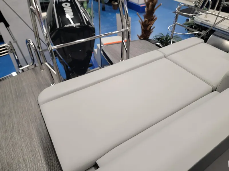 Slide: The Image of 2024 Harris Cruiser 230 boat with gray cushioned seating and outboard motor. - 18