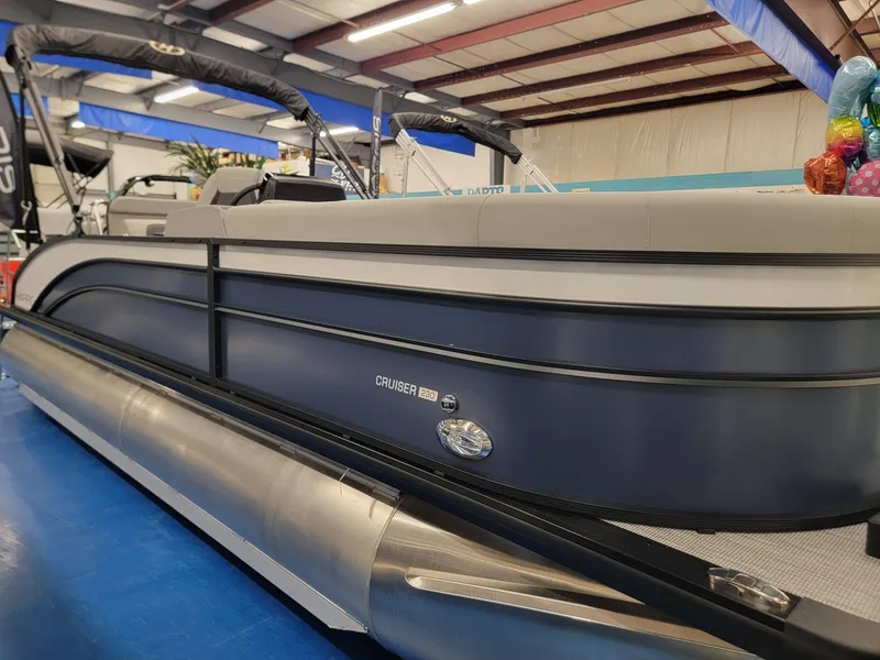 Slide: The Image of 2024 Harris Cruiser 230 pontoon boat in showroom. - 2