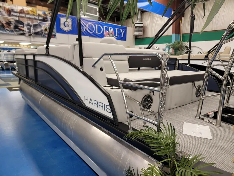 Slide: The Image of 2024 Harris Cruiser 230 pontoon boat on display indoors. - 4