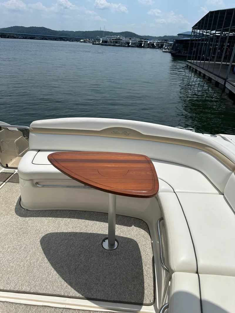 Slide: The Image of 2008 Sea Ray 350 Sundancer boat with cushioned seating and wooden table on deck. - 17