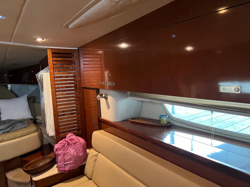 Slide: The Image of Interior of 2008 Sea Ray 350 Sundancer with wooden cabinets and beige seating. - 22