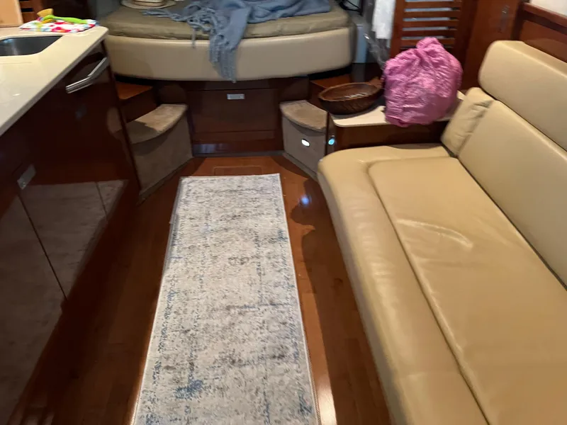 Slide: The Image of Interior of 2008 Sea Ray 350 Sundancer with beige seating and cozy bed area. - 24