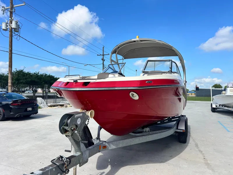 Slide: The Image of 2014 Yamaha Boats 242 Limited S in vibrant red on trailer under blue sky. - 4