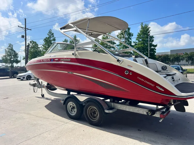 Slide: The Image of 2014 Yamaha Boats 242 Limited S, red, on trailer, sunny day. - 6