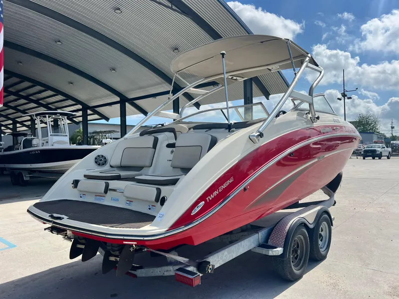 Slide: The Image of 2014 Yamaha Boats 242 Limited S, red and white, on trailer under a canopy. - 9