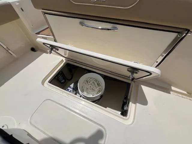 Slide: The Image of 2024 Scout 215XSF boat storage compartment with open hatch. - 11