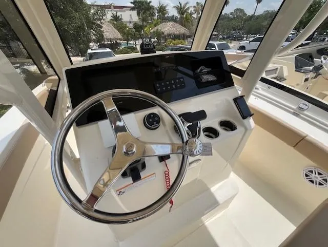 Slide: The Image of 2024 Scout 215XSF boat helm with steering wheel and control panel. - 12