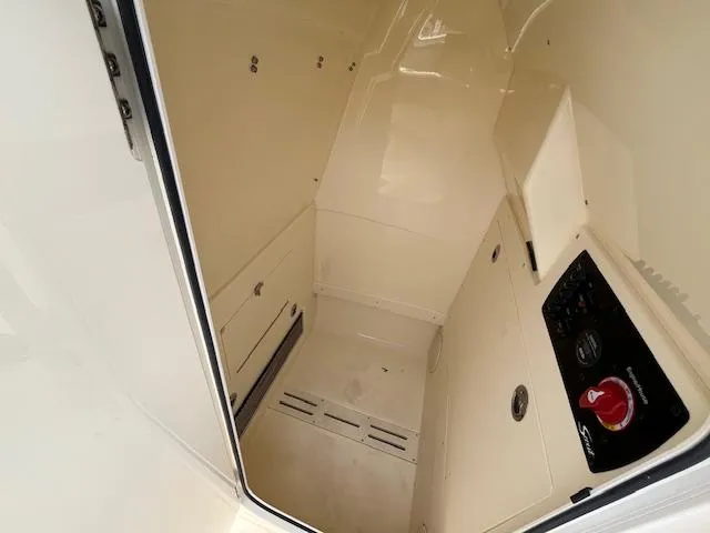 Slide: The Image of 2024 Scout 215XSF boat interior cabin with storage compartments and control panel. - 13