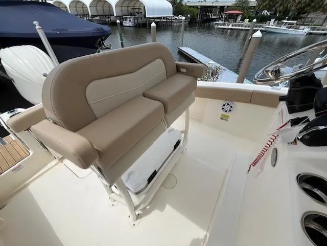 Slide: The Image of 2024 Scout 215XSF boat interior with beige seating and waterfront view. - 14