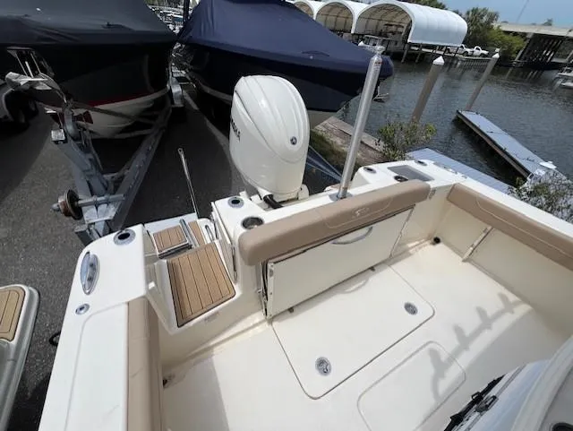 Slide: The Image of 2024 Scout 215XSF boat stern with outboard motor at marina. - 15
