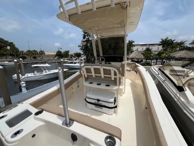 Slide: The Image of 2024 Scout 215XSF boat docked at marina, featuring center console and T-top. - 5