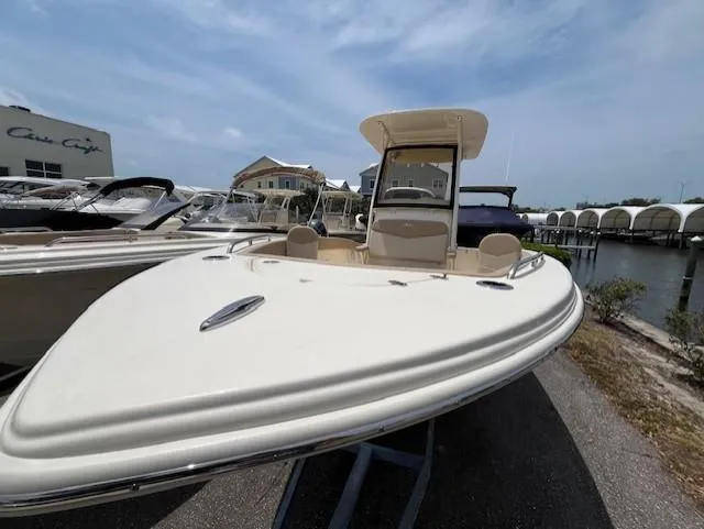 Slide: The Image of 2024 Scout 215XSF boat docked near waterfront homes and other boats. - 6