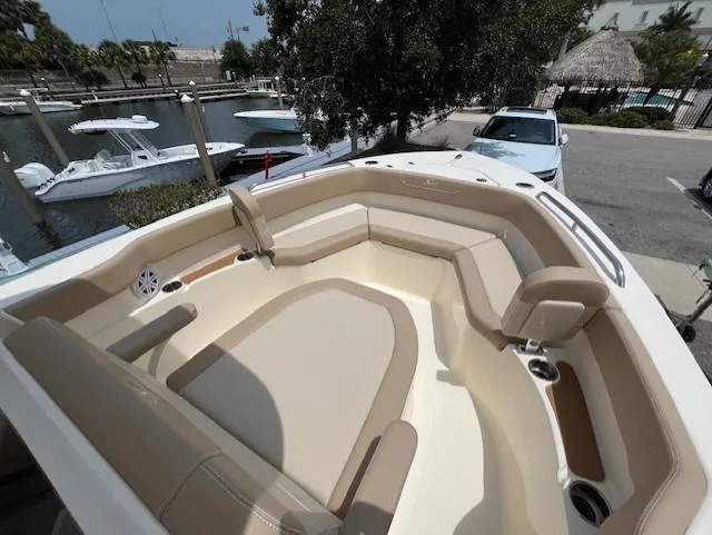 Slide: The Image of 2024 Scout 215XSF boat with spacious seating at a marina. - 8