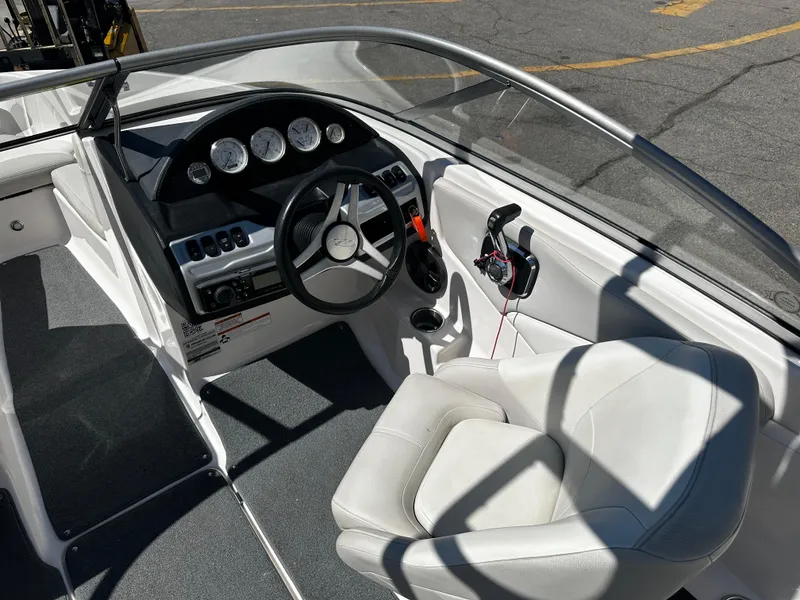 Slide: The Image of 2018 Regal 1900 ES Bowrider cockpit with steering wheel and white captain's seat. - 15