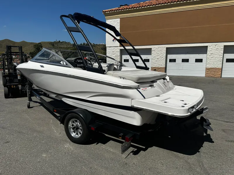 Slide: The Image of 2018 Regal 1900 ES Bowrider boat on a trailer in a parking lot. - 5