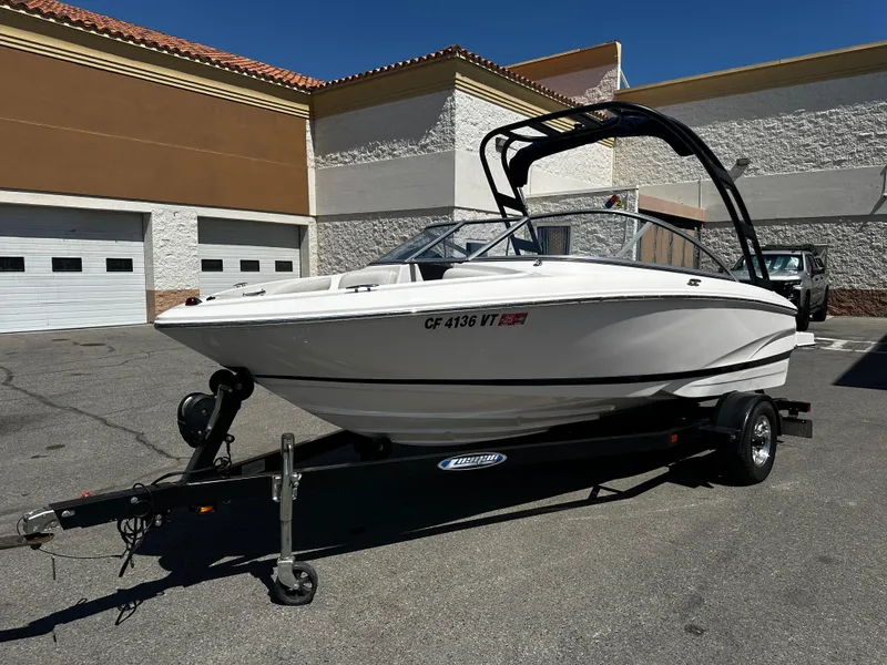Slide: The Image of 2018 Regal 1900 ES Bowrider boat on a trailer in a parking lot. - 6