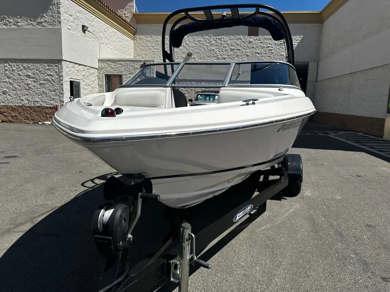 Slide: The Image of 2018 Regal 1900 ES Bowrider boat on a trailer in a parking lot. - 7