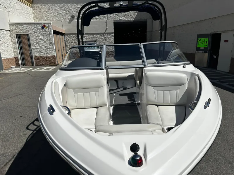 Slide: The Image of 2018 Regal 1900 ES Bowrider boat with white interior, parked outdoors. - 8