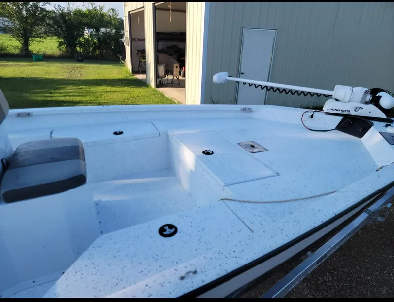 Slide: The Image of 2021 Xpress H20B boat with a Minn Kota trolling motor, parked near a garage. - 3