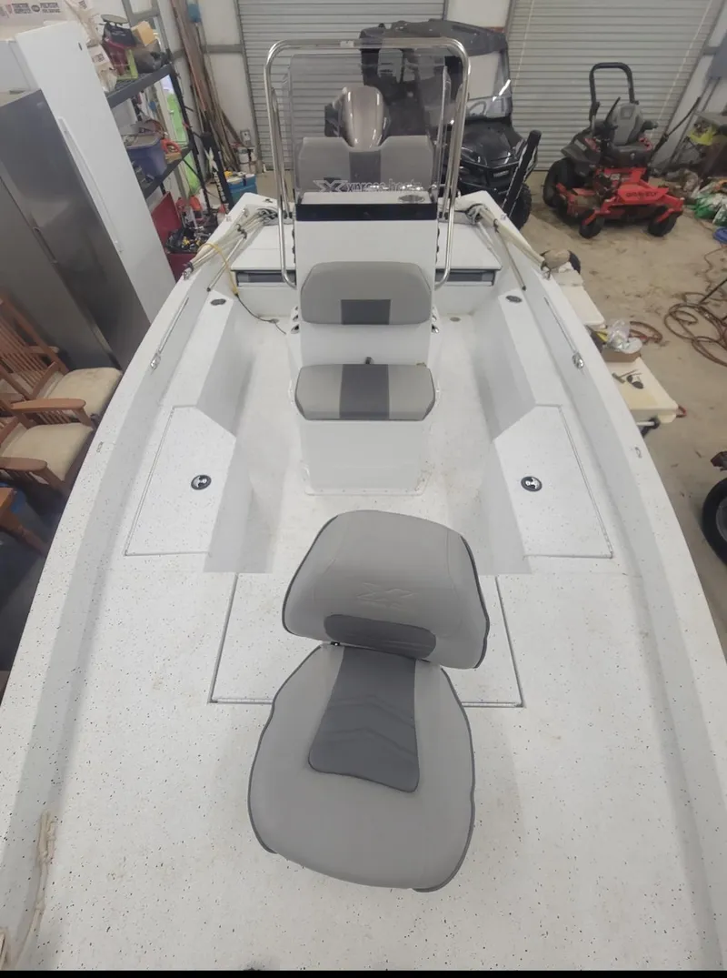 Slide: The Image of 2021 Xpress H20B boat interior with gray seating in a garage. - 9