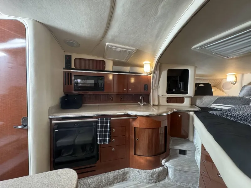 Slide: The Image of Interior of 2002 Sea Ray 310 Sundancer with kitchenette and sleeping area. - 2