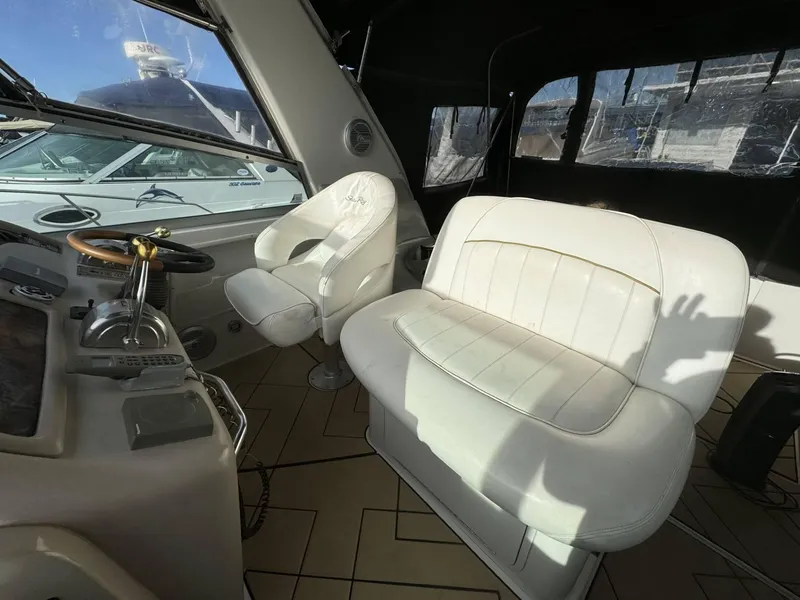 Slide: The Image of Interior cockpit of a 2002 Sea Ray 310 Sundancer boat with white seating. - 4