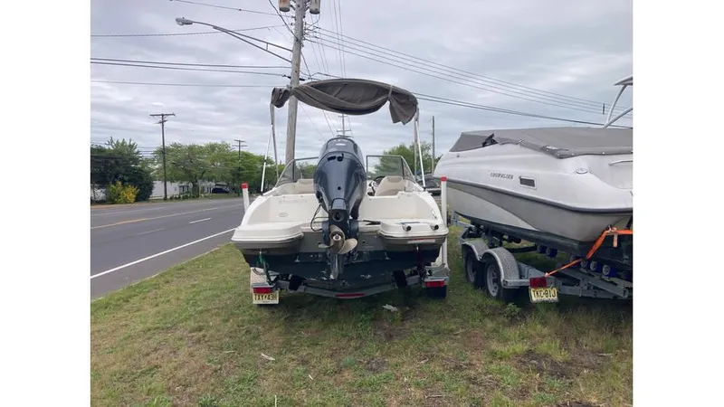 The Image of 2019 Stingray 190 DC boat parked on grass beside a road. - 1