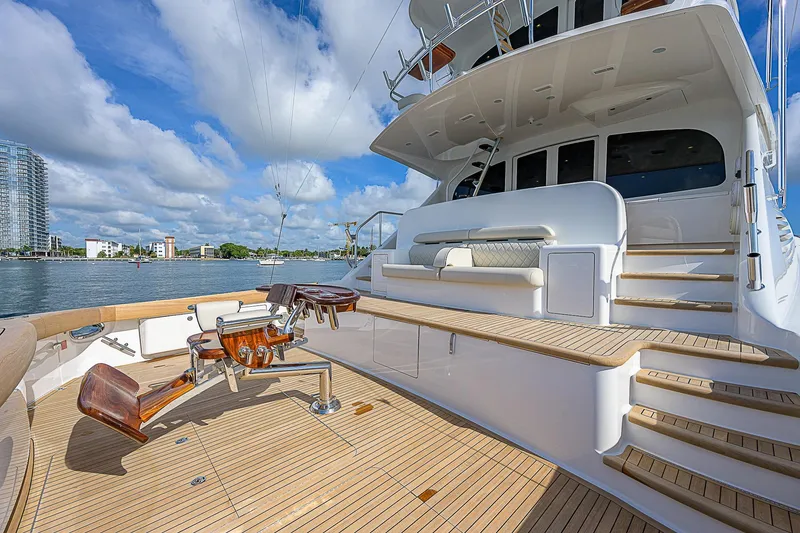 Slide: The Image of 2018 Viking 92 Sky Bridge yacht deck with fishing chairs and scenic water view. - 12