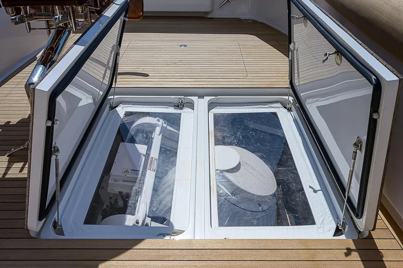 Slide: The Image of 2018 Viking 92 Sky Bridge yacht with open engine compartment on teak deck. - 16