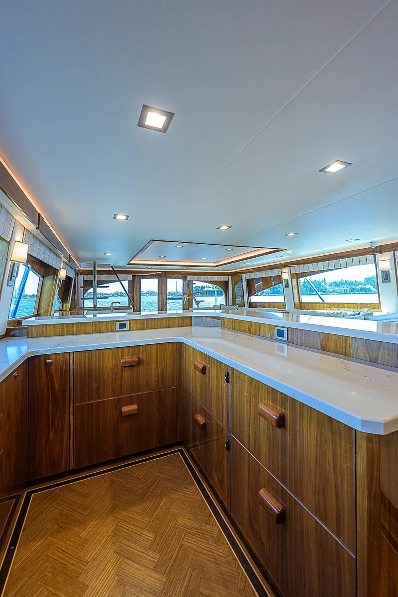 Slide: The Image of Luxurious interior of 2018 Viking 92 Sky Bridge yacht with wooden cabinetry and panoramic windows. - 27