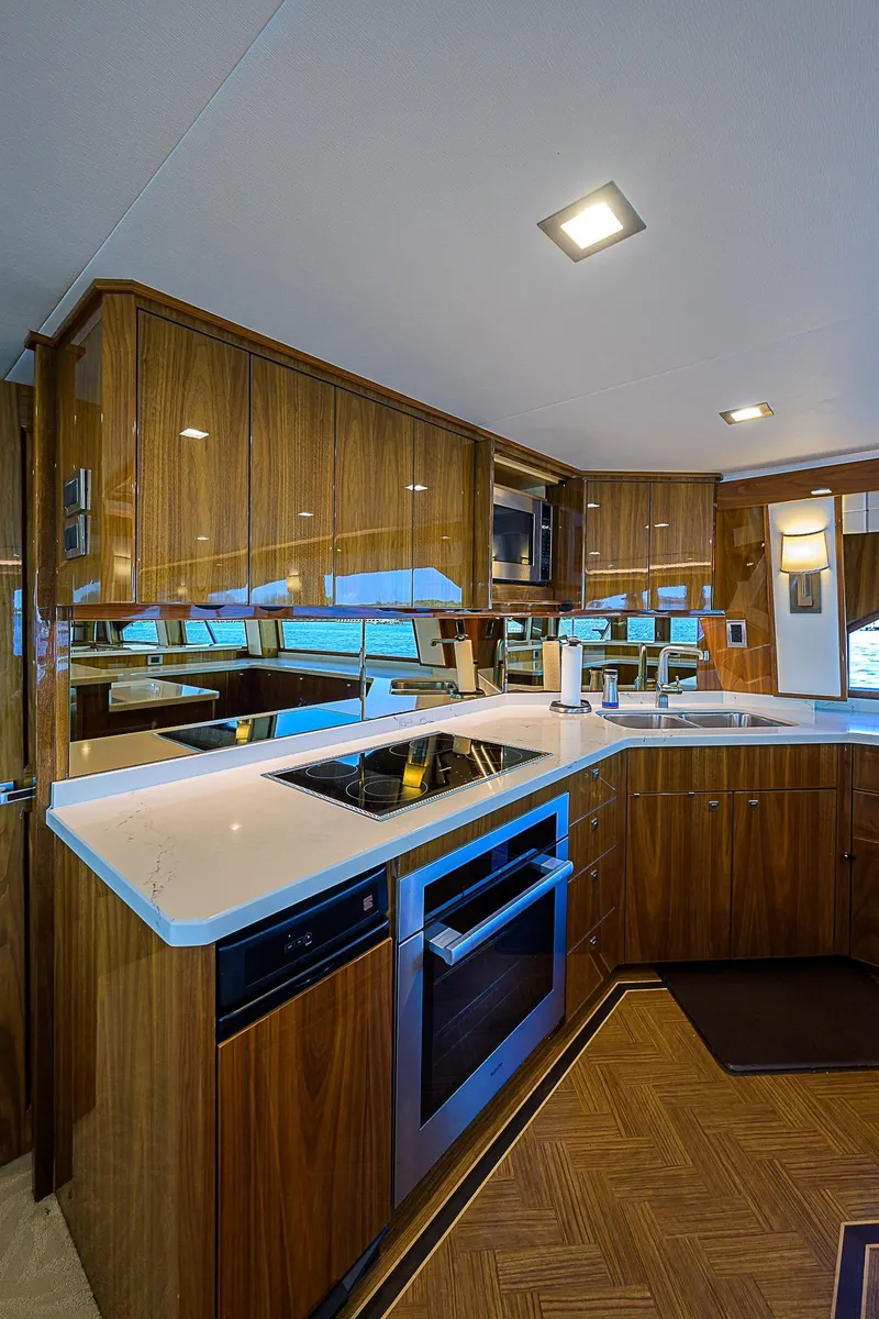 Slide: The Image of Modern kitchen in 2018 Viking 92 Sky Bridge yacht with sleek wood cabinetry and built-in appliances. - 28