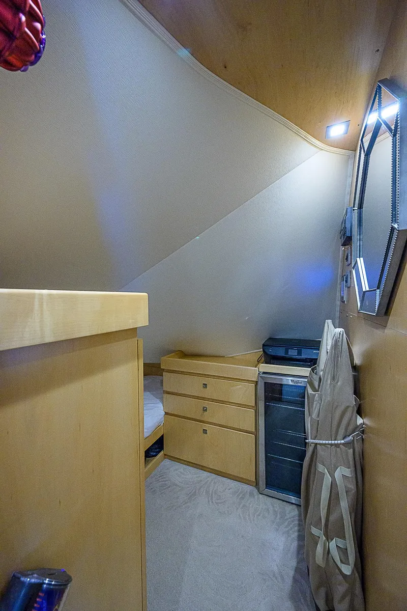 Slide: The Image of 2018 Viking 92 Sky Bridge interior cabin with storage drawers and mirror. - 35