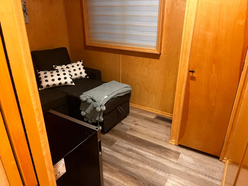 Slide: The Image of Cozy wooden interior with a black sofa, polka dot pillows, and a small fridge. Starlight 68X16, 2004 - 15