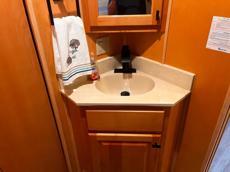 Slide: The Image of 2004 Starlight 68X16 bathroom sink with wooden cabinetry and black faucet. - 17